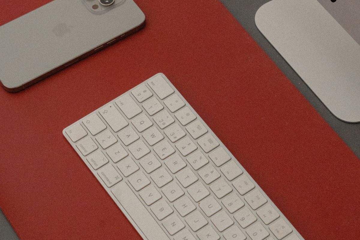 Representative photo: a keyboard and iPhone on a red desk mat. Not the Aothia product.